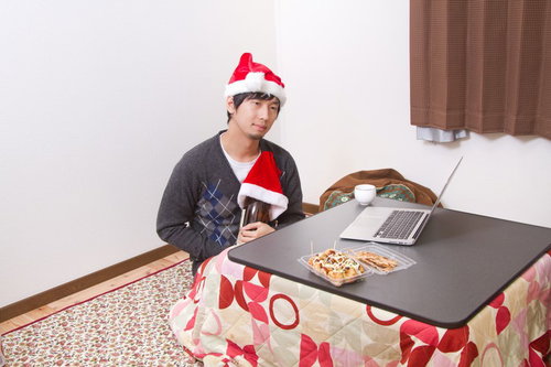 クリスマスにこたつで寂しく一升瓶を抱えて過ごす男性