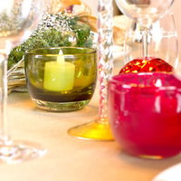 ろうそくの炎に照らされたテーブル上のシャンパングラスの写真