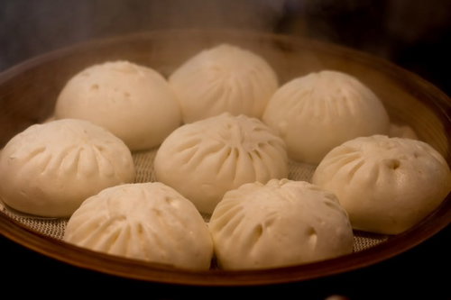白い蒸気が上がるホクホクの中華まんの接写
