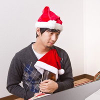 一升瓶を抱えてPCを見つめるクリぼっちの写真