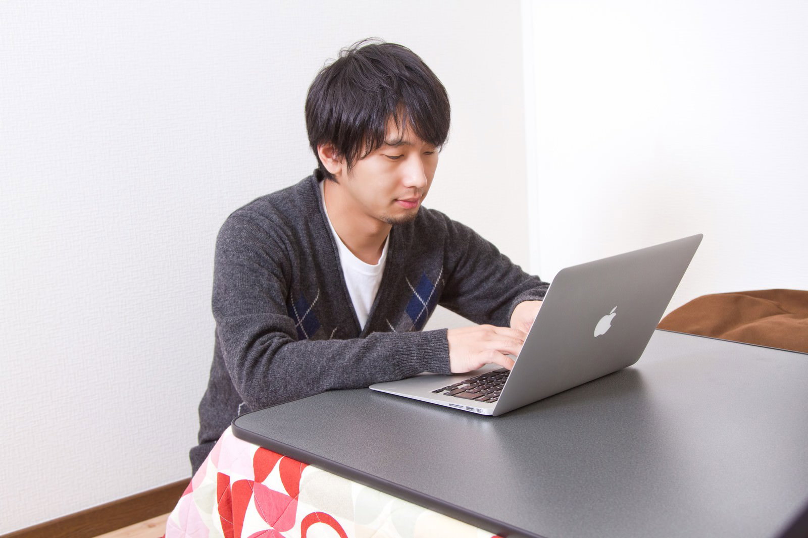 こたつでPC作業する冬の男性［モデル：大川竜弥］
