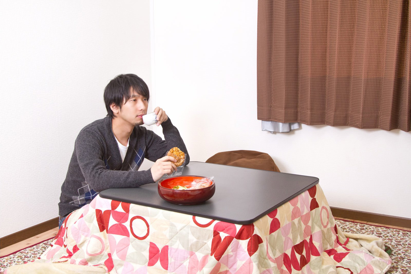 こたつで一人年末を過ごす男性［モデル：大川竜弥］