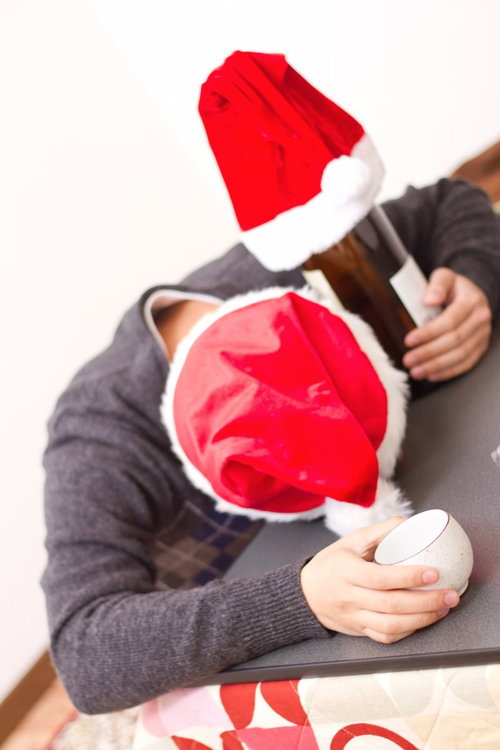 クリスマスにこたつの上で酔いつぶれて顔を伏せる男性