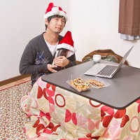 サンタ帽をかぶり酒瓶と聖なる夜を過ごす切ない表情のクリぼっちの写真