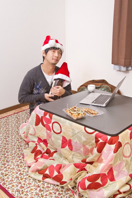 サンタ帽をかぶり酒瓶と聖なる夜を過ごす切ない表情のクリぼっち