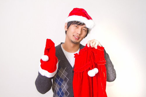 女性用のサンタコスプレ衣装を手に持って見せる男性