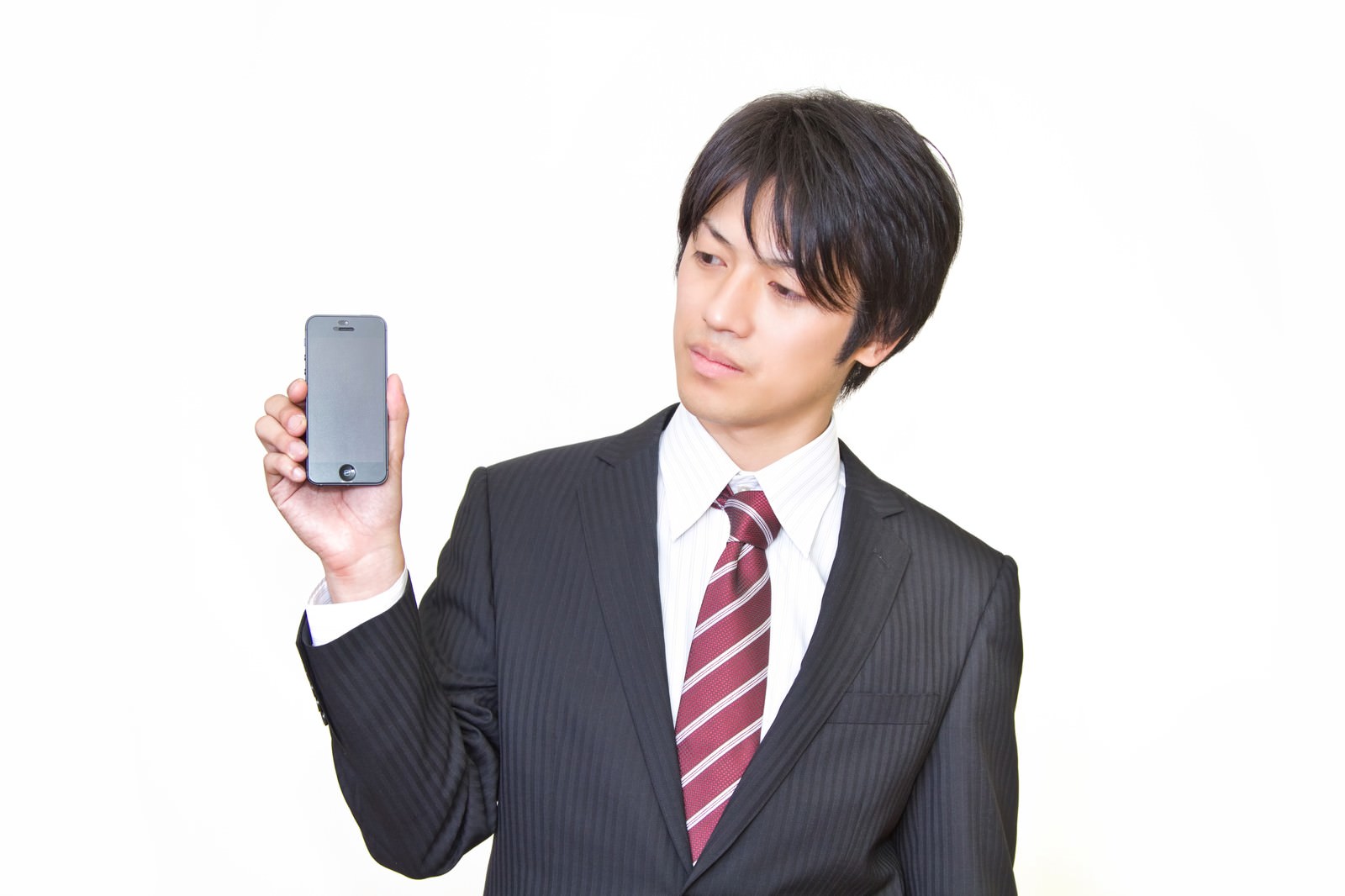 旧型スマホを見るサラリーマン［モデル：Tsuyoshi.］