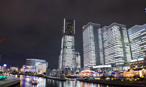 観覧車とビルの光が水面に映るタワーズミライトとコスモワールドの夜景