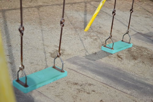 誰もいない静かな公園に等間隔で吊られたブランコ