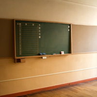 放課後の誰もいない教室に残るチョーク跡のある黒板の写真