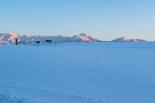 夕焼けのオレンジに染まる北海道の十勝岳の山並み