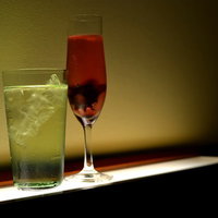 琥珀色のシャンパンが注がれた2つのグラスが並ぶテーブルの写真