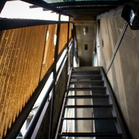 暗い照明の中で壁がむき出しの不気味なアパートの階段の写真