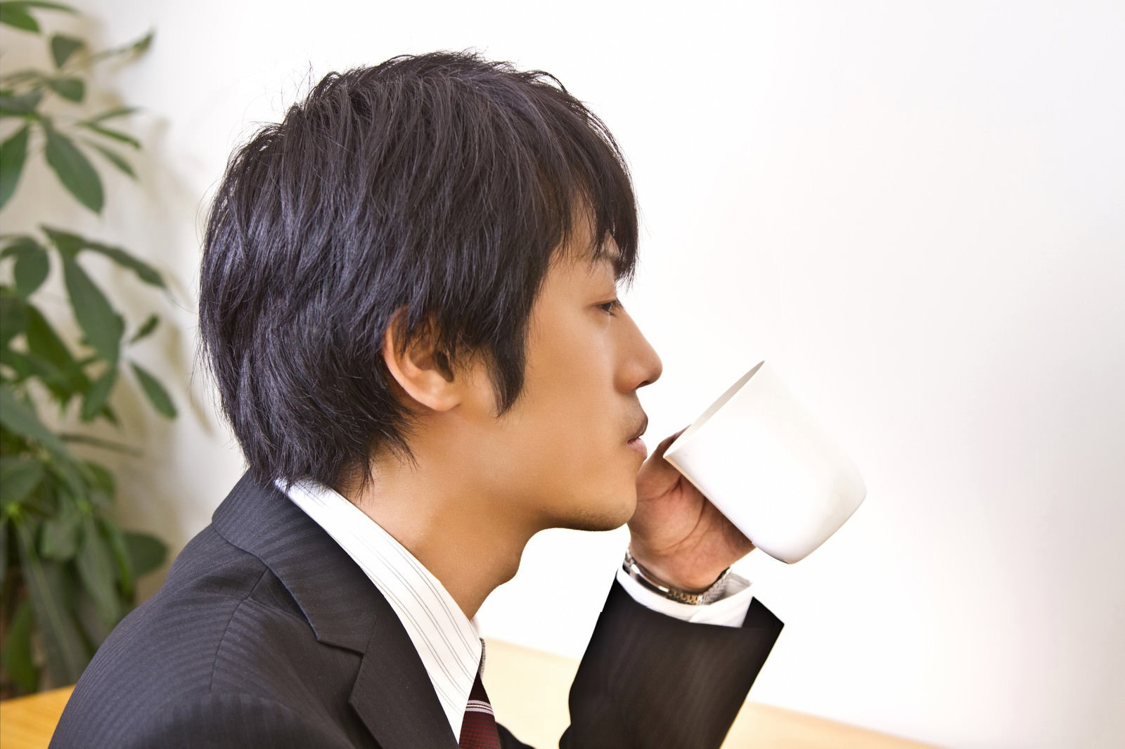 デスクでコーヒーを飲むサラリーマン［モデル：Tsuyoshi.］