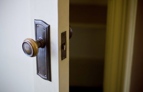 薄暗い部屋で半開きになったドアの向こうに光が差す