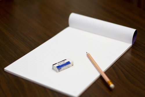 黄色い鉛筆とノートと消しゴムが並ぶ文房具セット