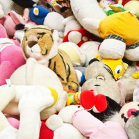 山積みにされ破棄された色とりどりのぬいぐるみの写真