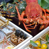 伊勢海老がひときわ目立つお正月のおせち料理の豪華な盛り付けの写真