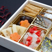 「寿」の文字が添えられた華やかなおせち料理の重箱の写真