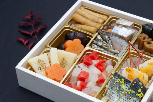 「寿」の文字が添えられた華やかなおせち料理の重箱