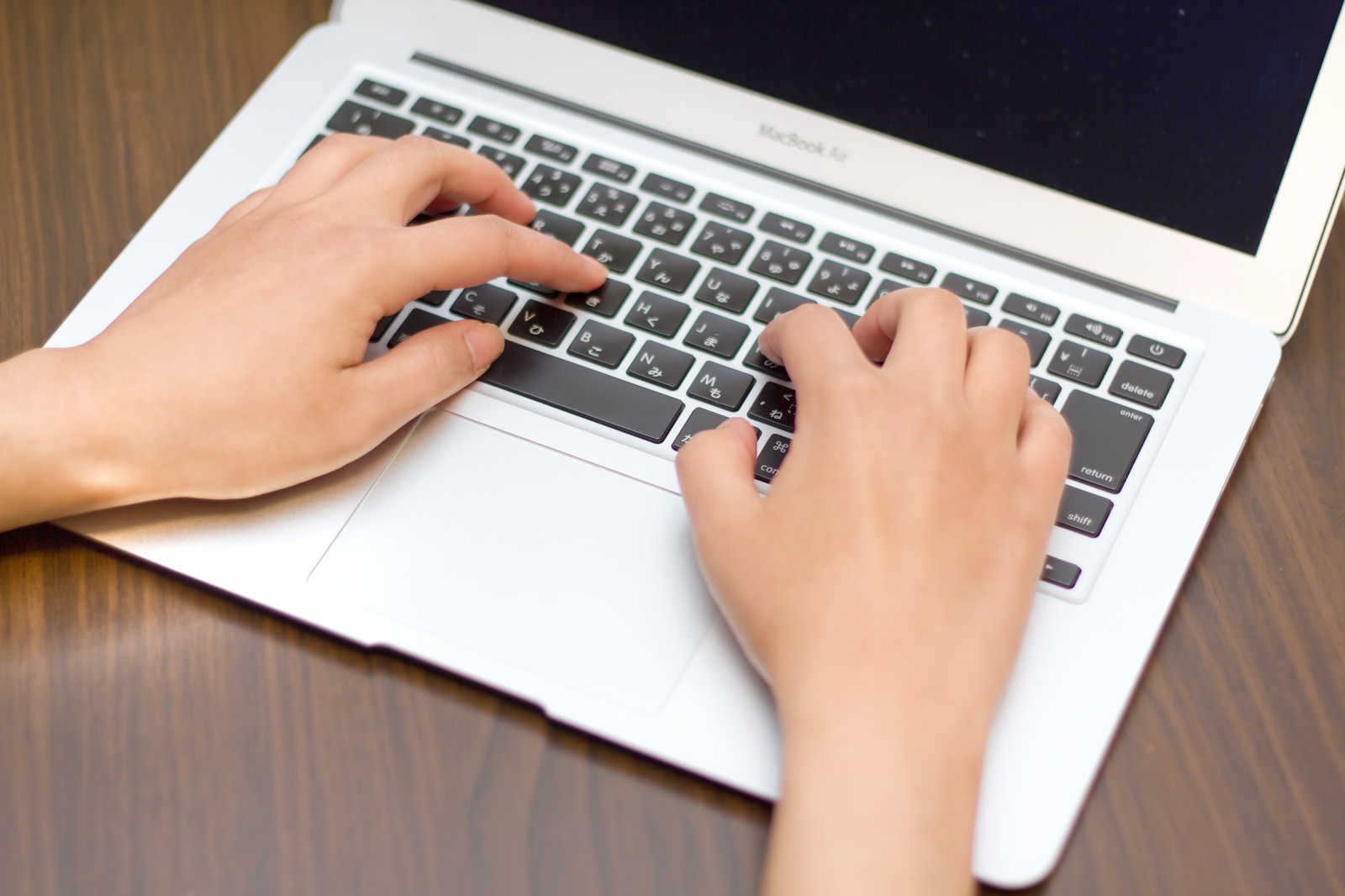 MacBook Airのキーボードを入力する両手