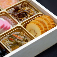 伊達巻や黒豆など色合いのよいおせち料理の各品の写真