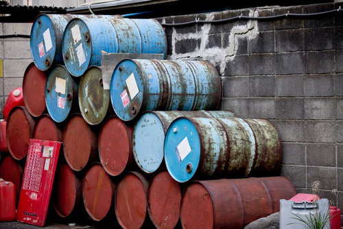 屋外に積み重ねられた錆びた古いドラム缶