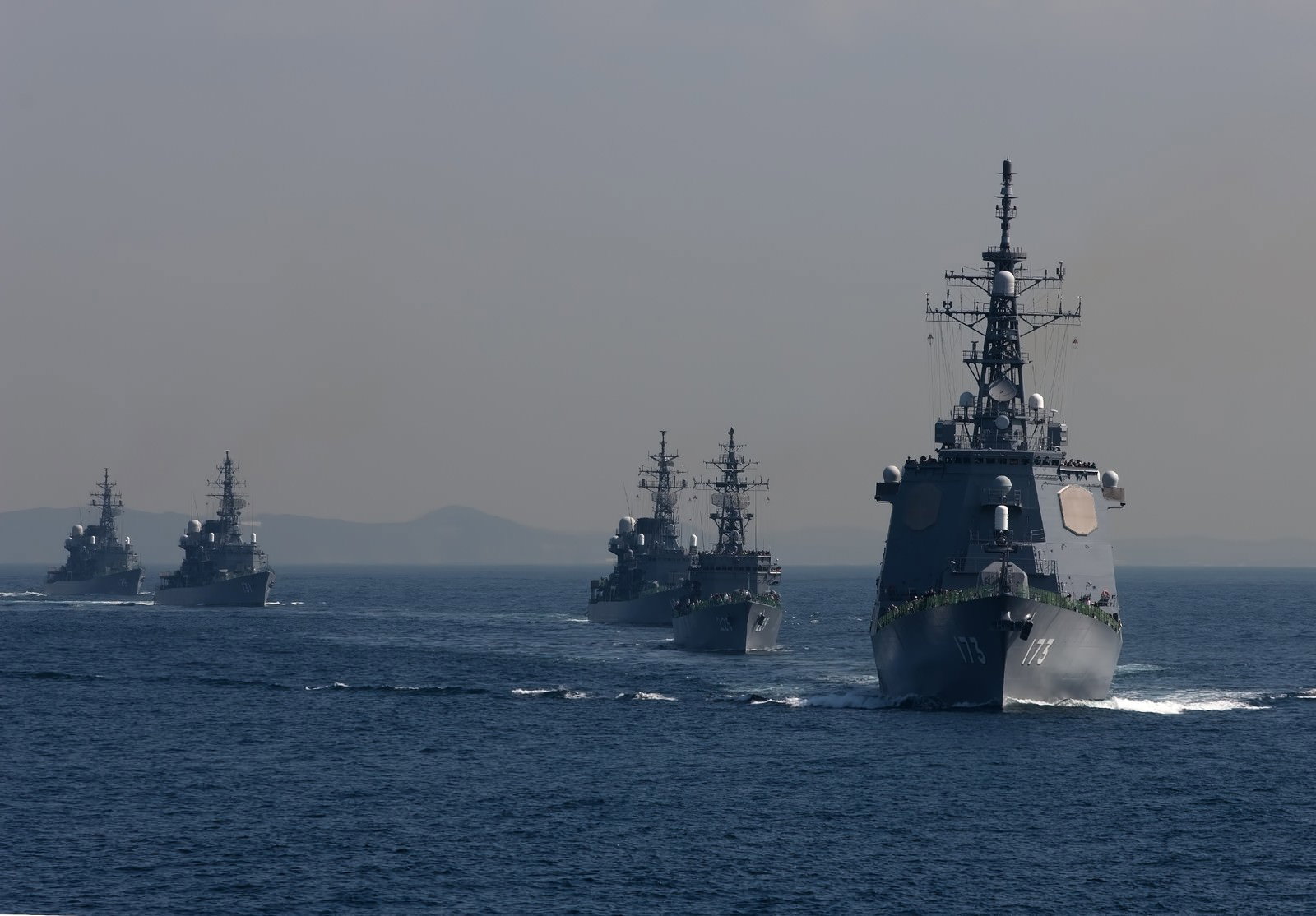 洋上を航行するイージス艦と護衛艦の艦隊
