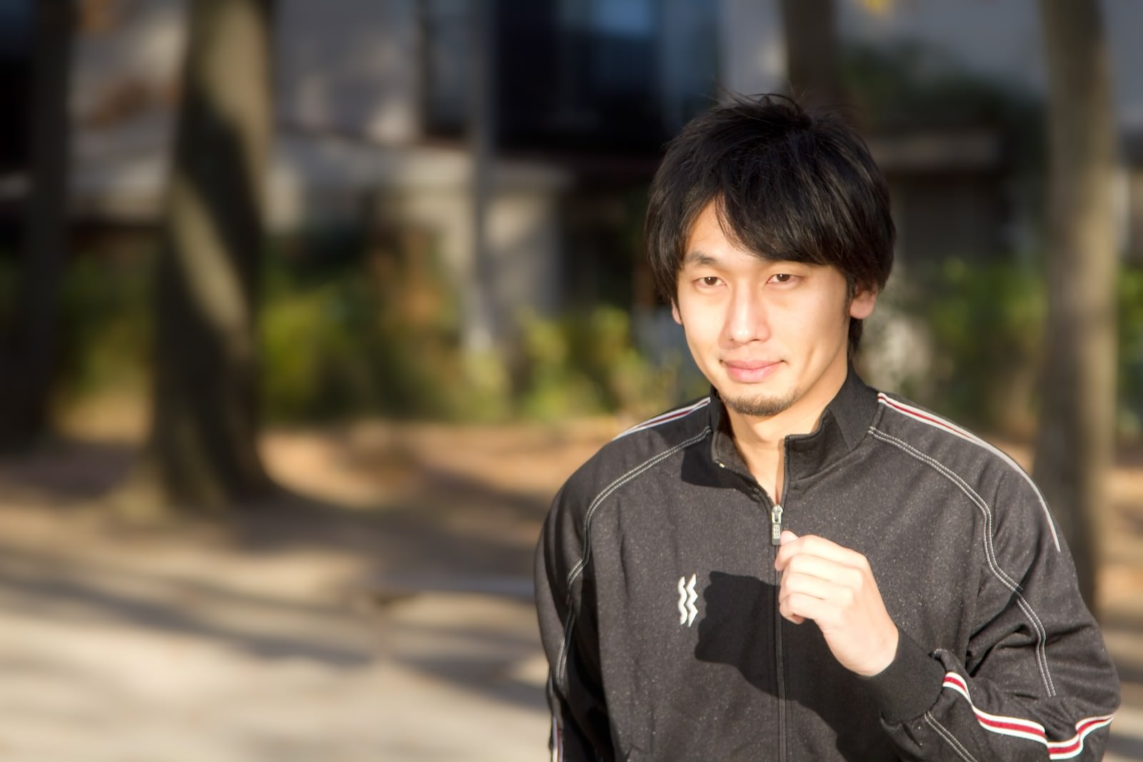 公園をジャージでランニングする男性［モデル：大川竜弥］