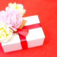 花束とリボンが結ばれたプレゼントの箱が並ぶギフトセットの写真