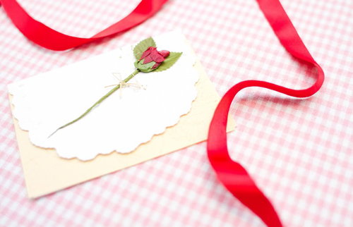 赤いリボンが結ばれた封筒と白い手紙のレターセット