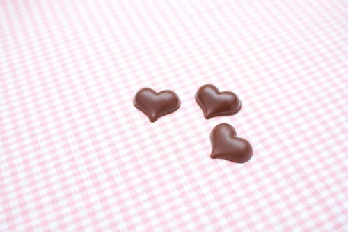 ピンクのランチョンマットの上に置かれたハート型チョコレート