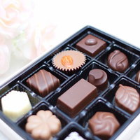 白いバラの造花とチョコレートが並ぶ上品なバレンタイン飾りの写真