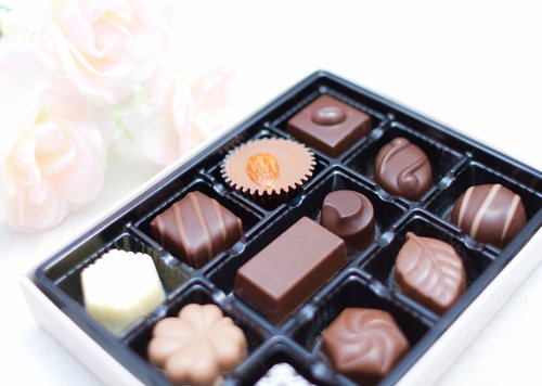 白いバラの造花とチョコレートが並ぶ上品なバレンタイン飾り