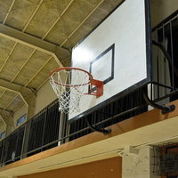 天井の照明に照らされた体育館のバスケットゴールの見上げの写真