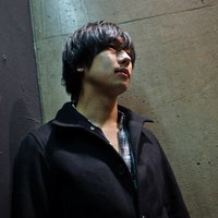 冷たいコンクリートの壁にもたれてうつむく疲れた男性の写真