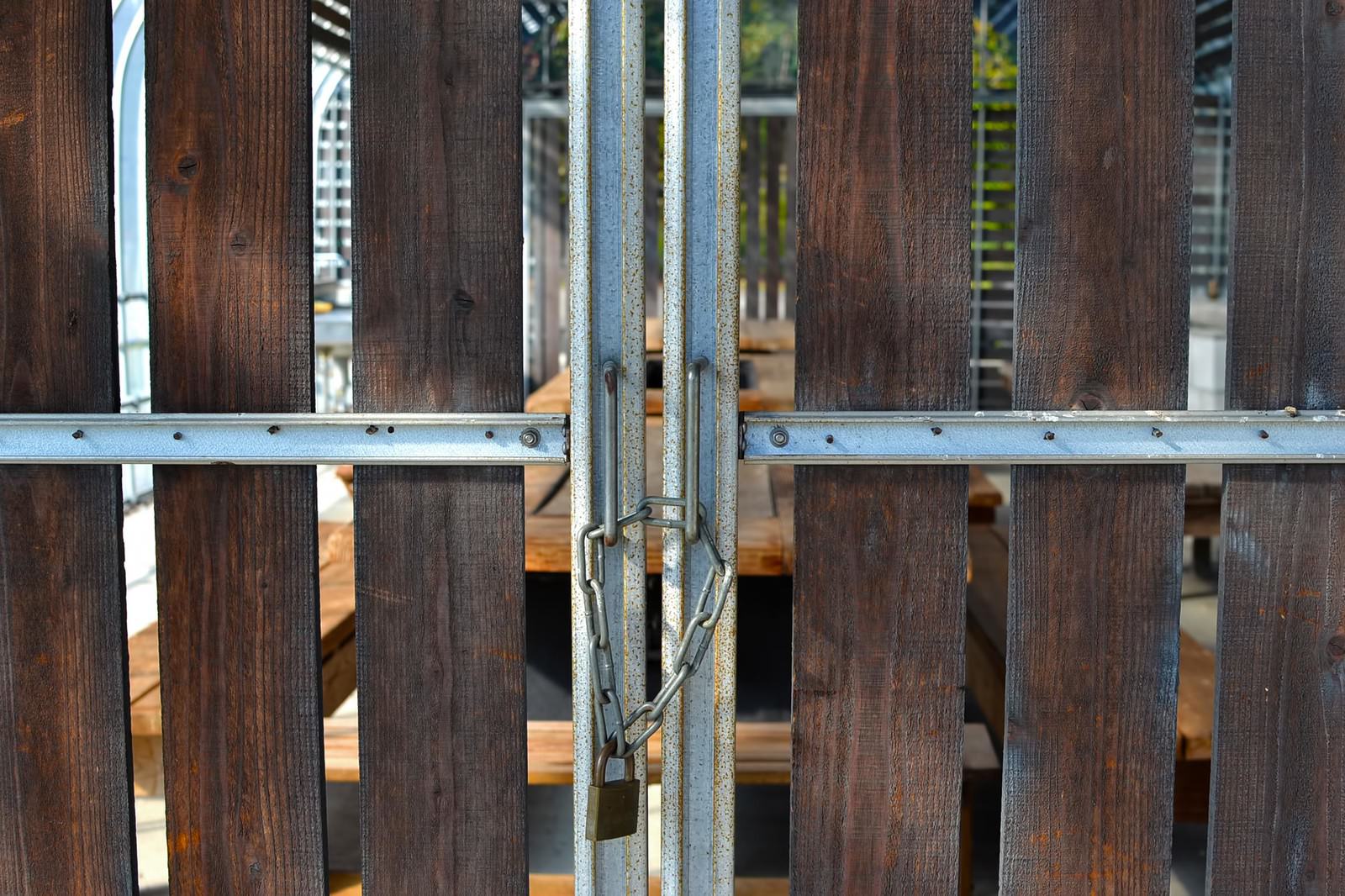 南京錠とチェーンで施錠された木製格子扉