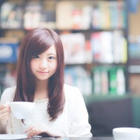 カフェで白いカップを持つ美少女がティータイムを楽しむの写真