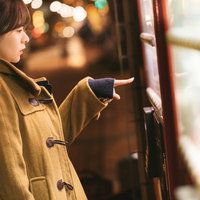 自販機の「あったか～い」を買うコートを着た女性の写真