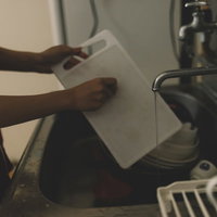 台所で洗い物中の手元 白いシンクと蛇口のあるキッチン風景の写真