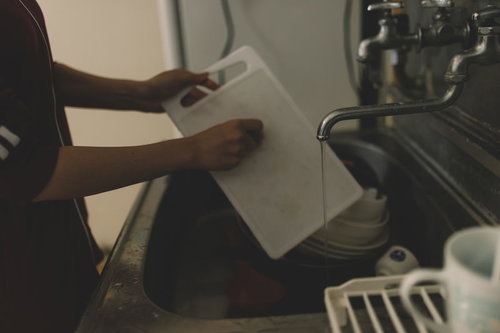 台所で洗い物中の手元 白いシンクと蛇口のあるキッチン風景