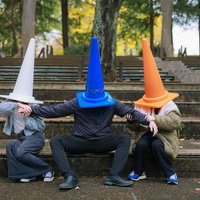 二人の女性からひっぱられる三角コーン（33歳男性）の写真