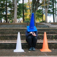 仲間を失いアプリで募集をかける三角コーンマンの写真