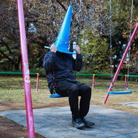 失職して公園ブランコの三角コーンマンの写真