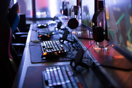 PCゲーム用のキーボードとモニターが並ぶeスポーツ施設の対戦卓