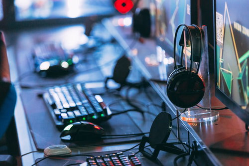 eスポーツ施設のゲーミングデスク上に配置されたキーボードとヘッドセット