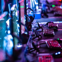 ネオンライトでライトアップされたeスポーツ施設のゲーミングキーボードの写真