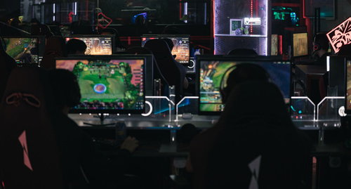 eスポーツ施設内で複数のプレイヤーがモニターに向かってゲームをプレイする人たち