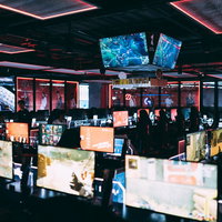 eスポーツ施設内で様々なゲームをプレイするプレイヤーとモニターの様子の写真