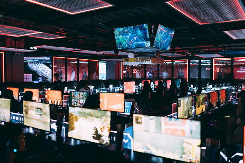 eスポーツ施設内で様々なゲームをプレイするプレイヤーとモニターの様子
